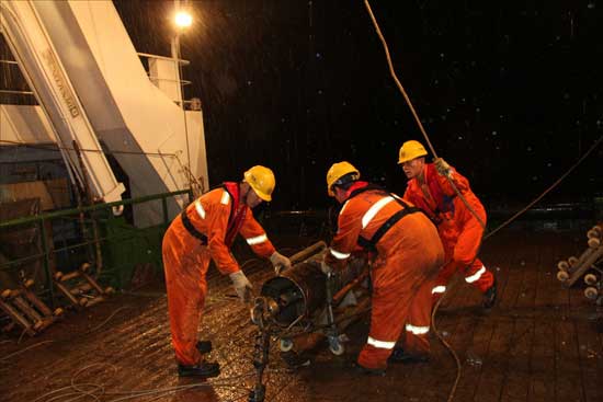 “海洋六号”科考队员太平洋雨夜中作业收样品